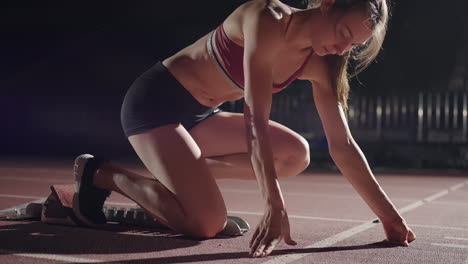 Woman-hand-on-track-as-he-crouches-in-starting-position-at-the-beginning-of-a-race.-Female-Athlete-Prepare-And-Start.-Runner-hands-waiting-at-the-start-in-front-of-the-starting-line-at-the-ground.